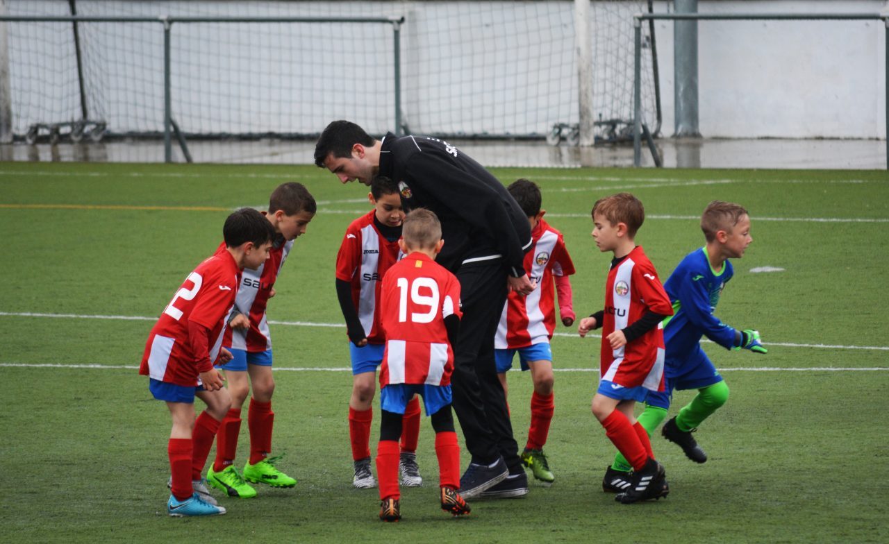 youth soccer players huddled around coach