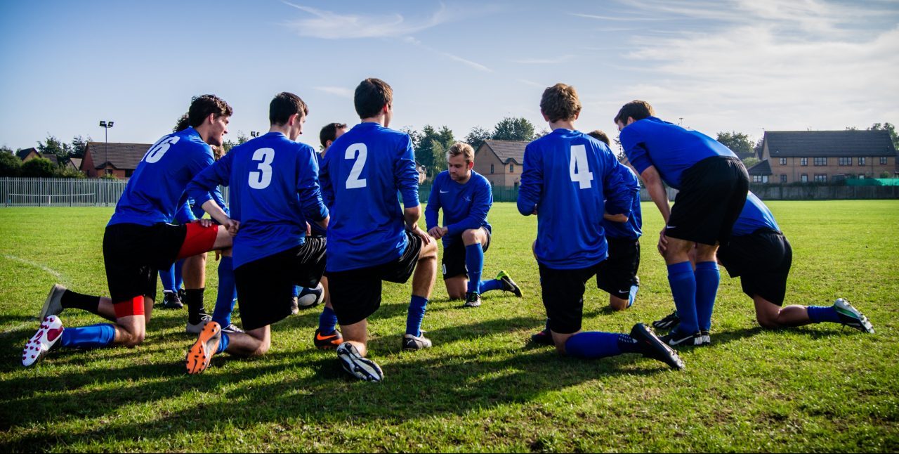 soccer team kneeling in huddle